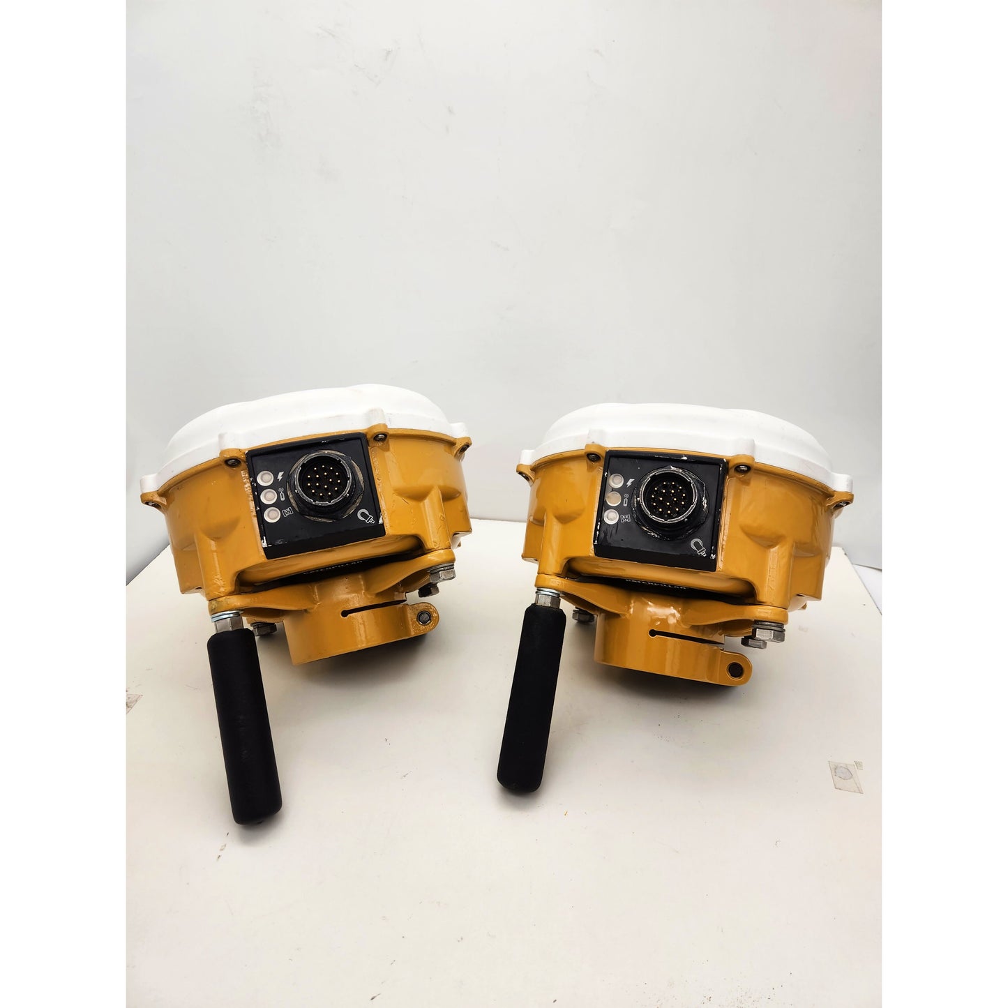 Lot of two Caterpillar MS992 Smart Antennas showing dual GNSS receiver connectors and rugged yellow housing for CAT Accugrade system.