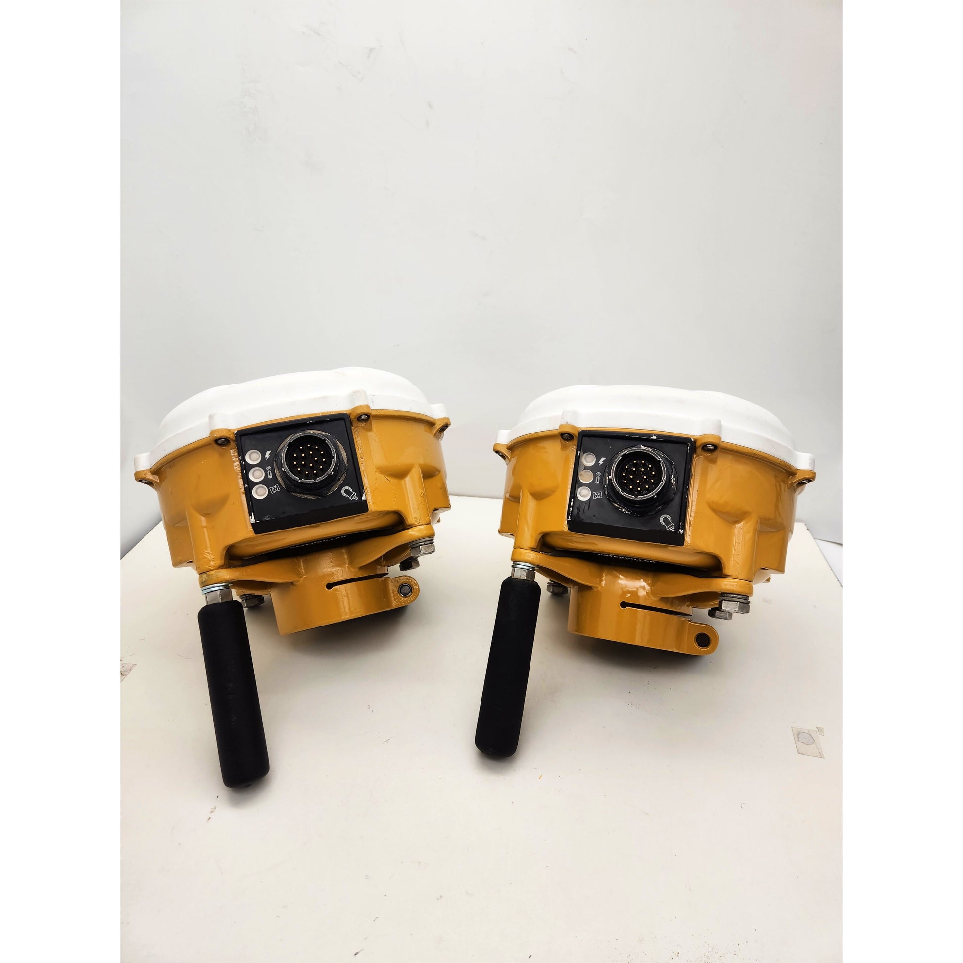 Lot of two Caterpillar MS992 Smart Antennas showing dual GNSS receiver connectors and rugged yellow housing for CAT Accugrade system.